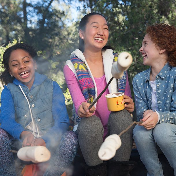 three girls roasting marshmallows 